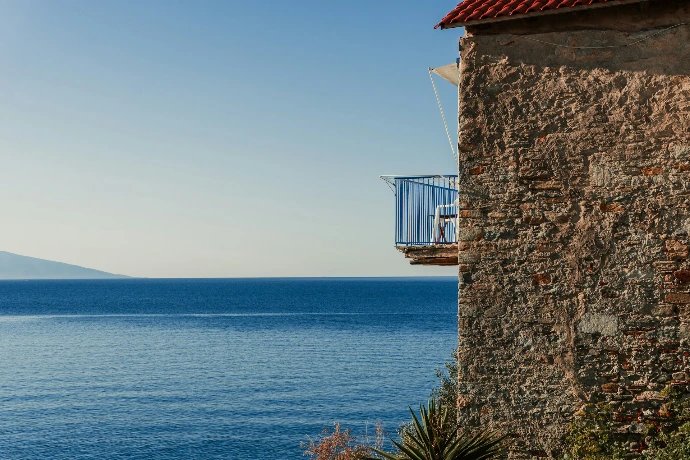 a stone building with a balcony overlooking the ocean